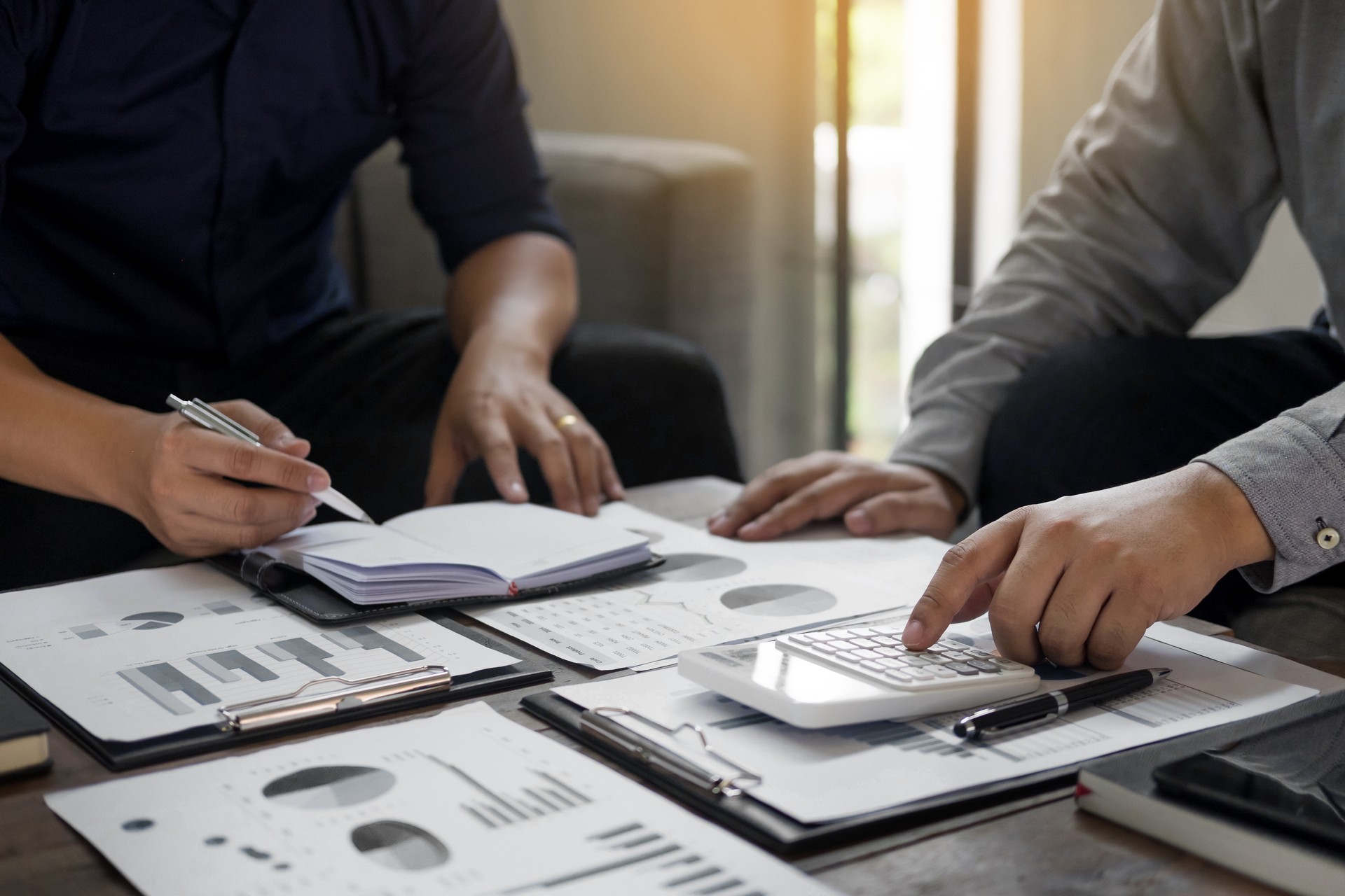 Midsection Of Businessmen Doing Paperwork In Office