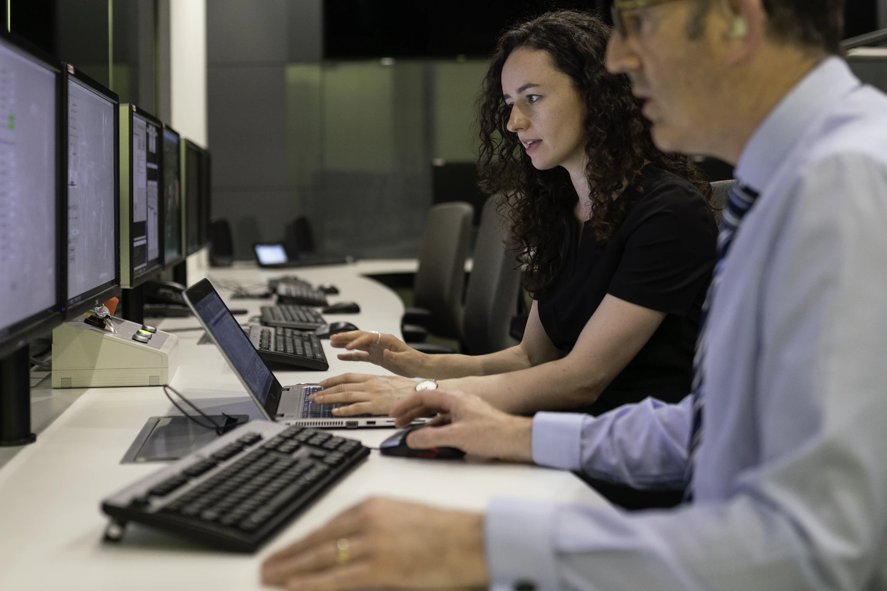 Deux analystes au travail devant les écrans d’un centre de supervision